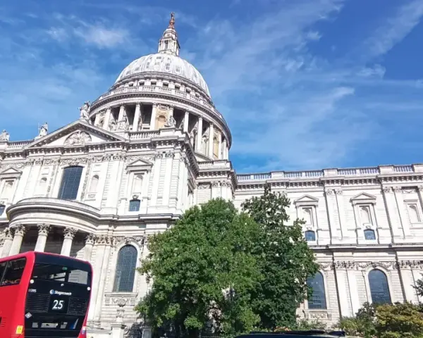 Majestatyczna katedra św. Pawła w Londynie, czerwony piętrowy autobus i błękitne niebo. Idealny widok na udany weekend w Londynie.