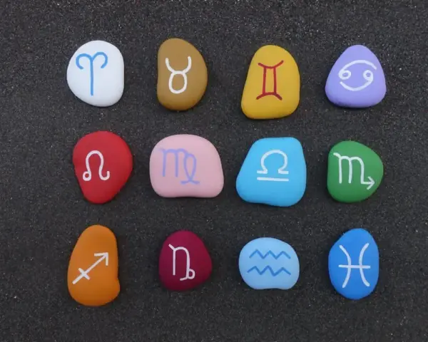 Kolorowe kamienie z symbolami zodiaku, ułożone w rzędach. Idealne do sprawdzania dopasowania znaków zodiaku.