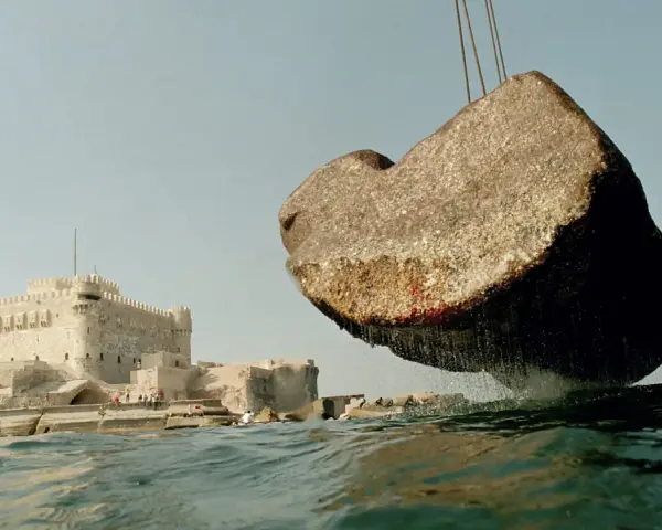 Un bloc de pierre, vestige du phare d'Alexandrie, est soulevé au-dessus des eaux, près de la citadelle de Qaitbay.