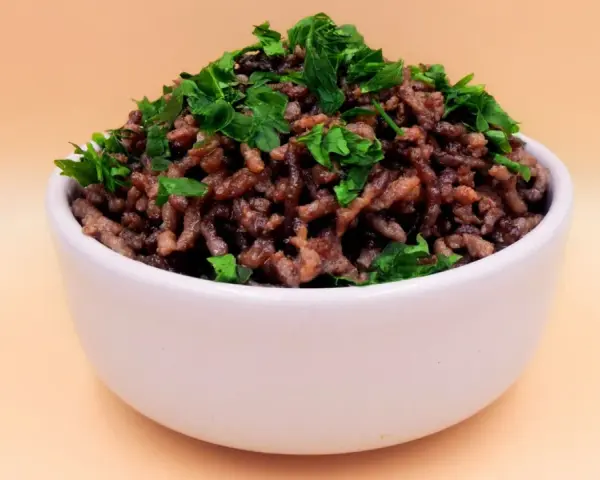 Mielona wołowina z natką pietruszki w białej miseczce. Idealna baza do wielu dań, np. do sosu bolognese. Prosty przepis na wołowinę.