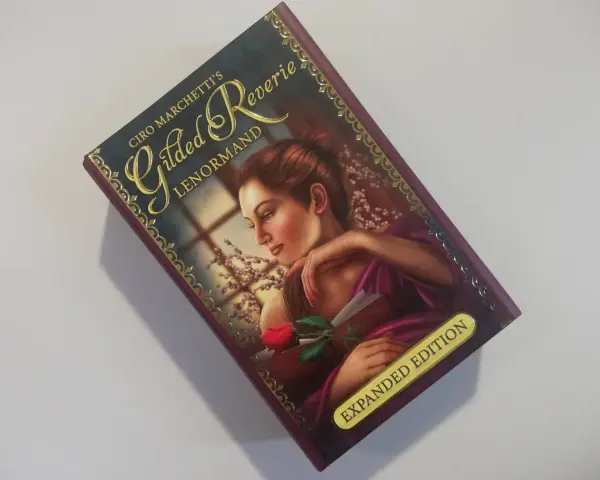 Okładka talii "Gilded Reverie Lenormand" Ciro Marchetti. Kobieta z różą, idealna do wróżb na dziś.