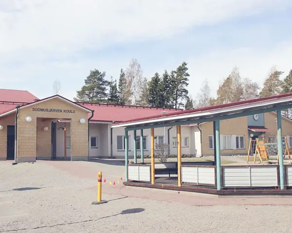 Suomusjärven Koulu, czyli szkoła w Finlandii, z placem zabaw i zielonymi terenami. Ciekawostki o fińskim systemie edukacji często podkreślają jego innowacyjność.