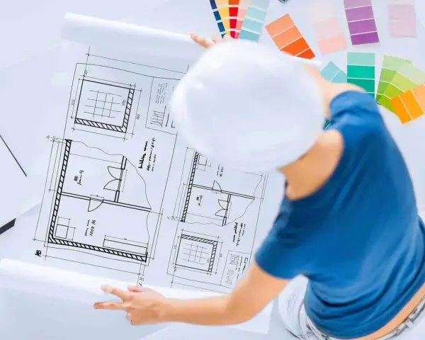 Pracownia znanych projektantów wnętrz: szkice planów, palety kolorów i biały kask.