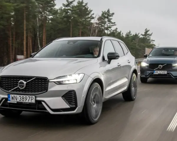 Dwa Volvo XC60 T8 jadące po drodze leśnej. Jeden srebrny, drugi ciemnoszary.