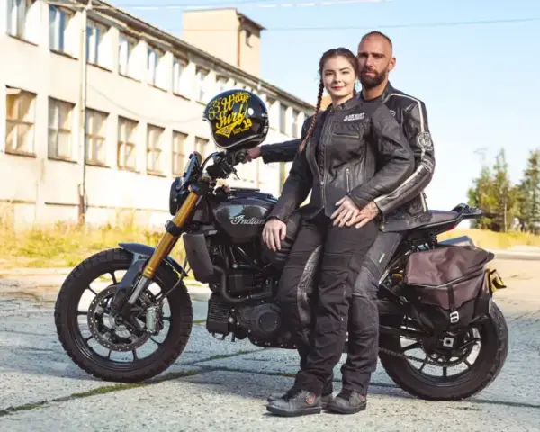 Para motocyklistów w skórzanych kurtkach siedząca na motocyklu Indian, z kaskiem.