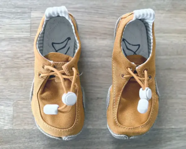 Braune Lauflernschuhe mit Schnürung und Gummizug. Ideal für die ersten Schritte, ab wann sie gebraucht werden, hängt vom Kind ab.