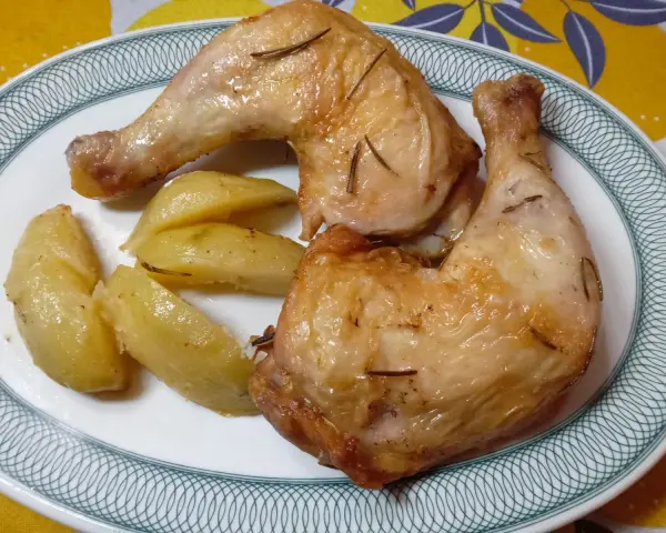 Cosce di pollo in friggitrice ad aria, dorate e succulente, servite con patate arrosto.