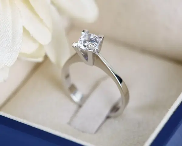 Anello con diamante in un cofanetto blu. La brillantezza del diamante, misurata in carati, cattura la luce.