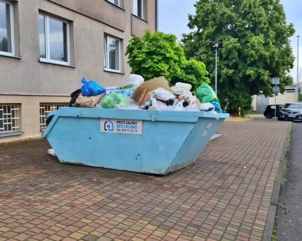 Kontener na śmieci pełen worków i odpadów, z napisem "Przyjazny Recykling". Data: 16 02 14.