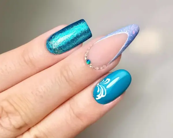 Unghie con glitter blu elettrico, french manicure con glitter azzurro e decorazioni floreali bianche. Nuove forme unghie che ispirano.