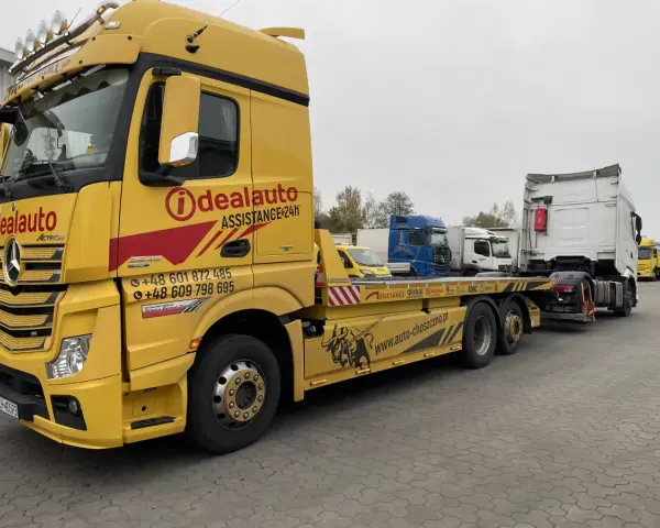 Żółta laweta "Idealauto" z numerami kontaktowymi. Zastanawiasz się, ile kosztuje laweta? Sprawdź ofertę tej firmy!