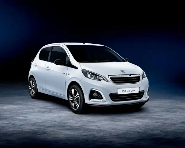 Biały Peugeot 108 GT Line stoi na ciemnym tle.