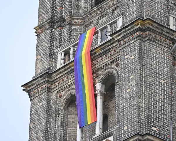 Regenbogenflagge hängt an einer Kirche. Die Bedeutung der Regenbogenflagge steht für Vielfalt und Akzeptanz.