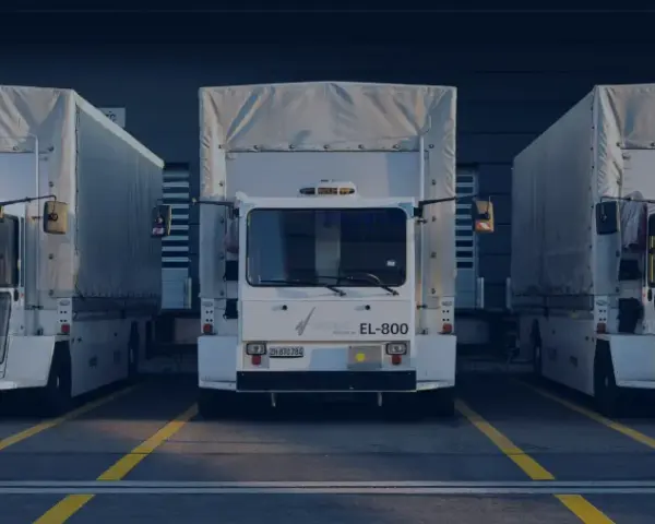 Drei weiße LKWs stehen nebeneinander vor einem Gebäude. Ein LKW-Fahrverbot am Wochenende könnte hier gelten.