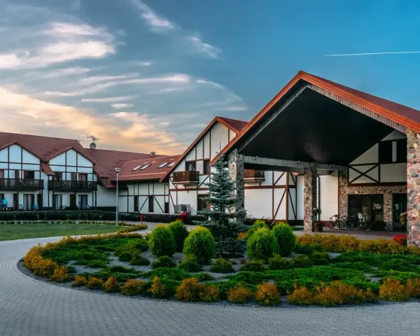 Elegancki hotel Mikołajki Spa z charakterystyczną architekturą i zadbanym ogrodem zaprasza na wypoczynek.