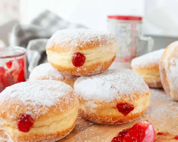 Frisch gebackene Krapfen im Airfryer, mit Puderzucker bestäubt und leckerer Marmelade gefüllt.
