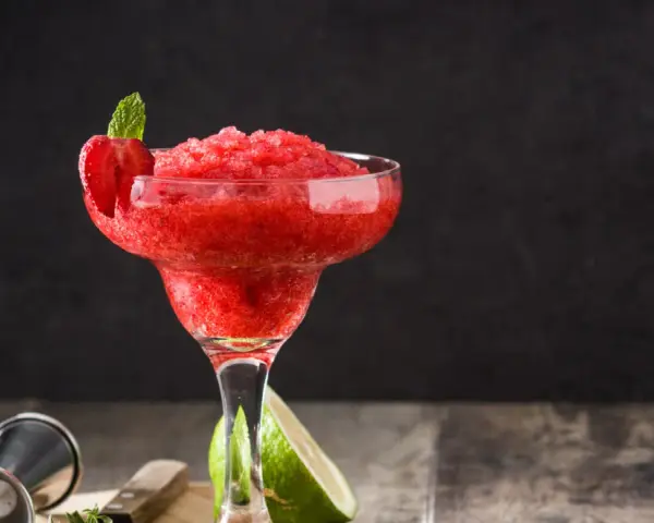 En fryst strawberry daiquiri med mynta och jordgubbsdekoration, redo att avnjutas.