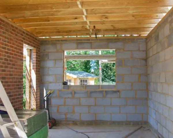 Budynek gospodarczy na zgłoszenie w trakcie budowy. Ściany z bloczków betonowych, drewniany strop, widok na ogród.