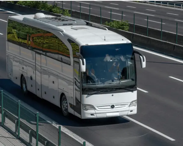 Biały autokar jedzie autostradą. Zastanawiasz się, ile pali bus na 100 km?