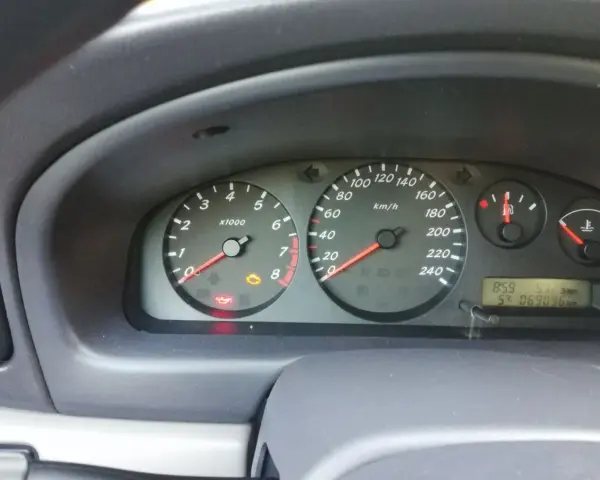 Migająca kontrolka samochodu z kluczykiem Nissan na desce rozdzielczej. Obok świeci się kontrolka oleju.