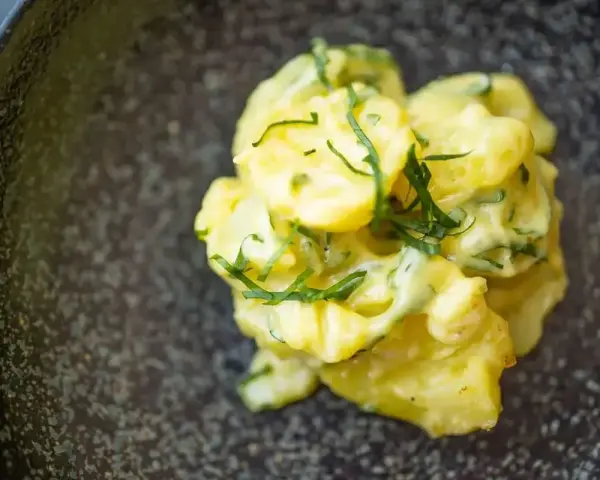 Cremiger Kartoffelsalat mit Mayonnaise, garniert mit frischen Kräutern. Ein klassisches Kartoffelsalat Rezept, das immer schmeckt.
