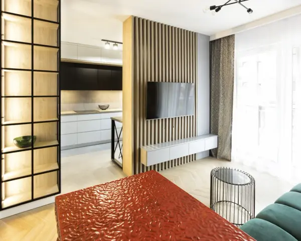 Nowoczesny, bardzo mały salon w bloku z otwartą kuchnią, drewnianymi panelami i designerskimi meblami.