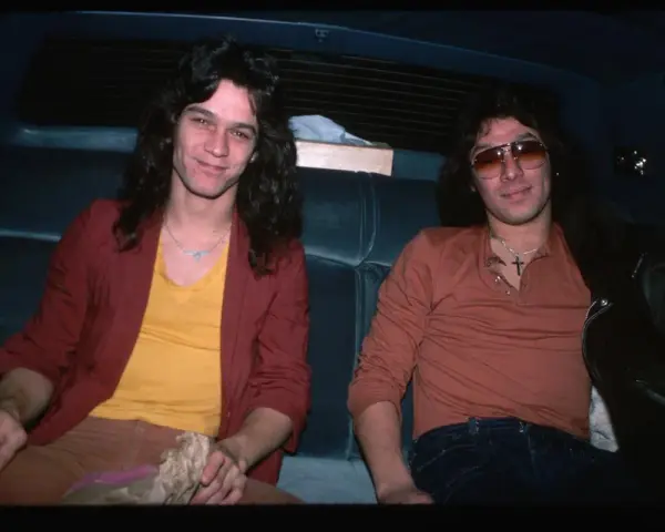 Alex Van Halen i jego brat Eddie Van Halen siedzą w samochodzie, obaj w stylowych ubraniach z lat 80.