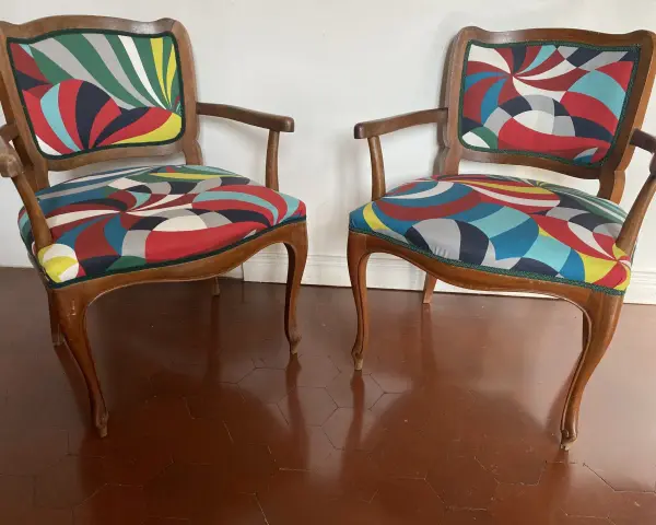 Due sedie con schienale rivestite con tessuto colorato e geometrico, un'idea per come rivestire una sedia con schienale.