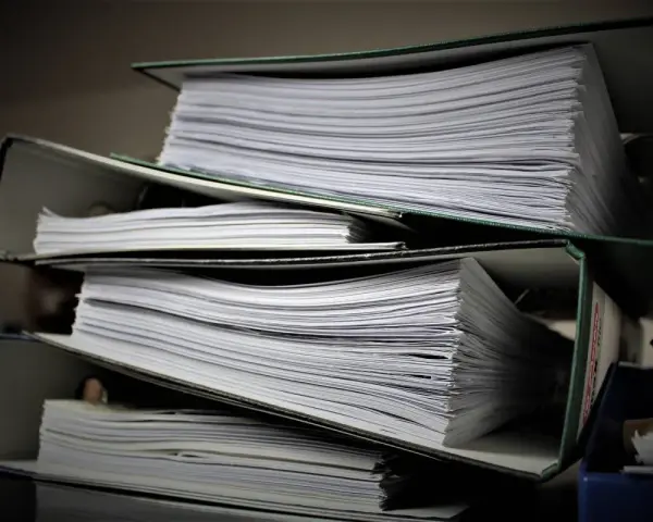 Stosy dokumentów w segregatorach, gotowe do złożenia jako list motywacyjny do urzędu.