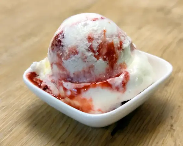 Ein Eisbecher mit Erdbeersoße, der zum sofortigen Genuss einlädt. Ein wahrer "Ed von Schleck" Moment!