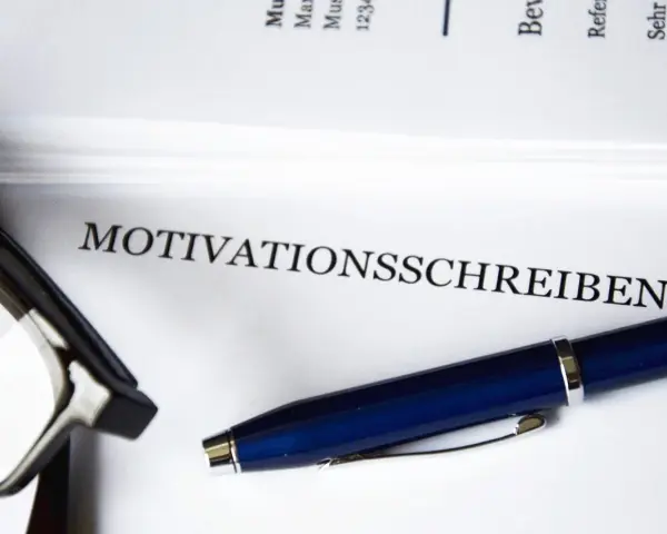 Okulary i długopis leżą obok dokumentu z napisem "MOTIVATIONSSCHREIBEN".
