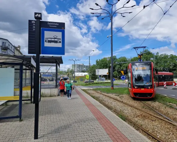 Przystanek Dęblińska w Sosnowcu. Tramwaj czeka na pasażerów, a rozkład jazdy MZK jest widoczny na słupie.
