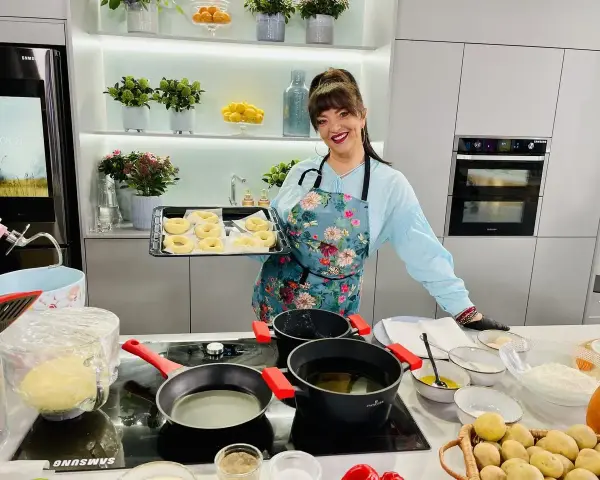 Cristina Catese przygotowuje pączki. Na blacie widać składniki i gotowe ciasto.
