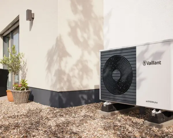 Unità esterna Vaillant per raffrescamento con termosifoni, posizionata su ghiaia vicino a una casa moderna.