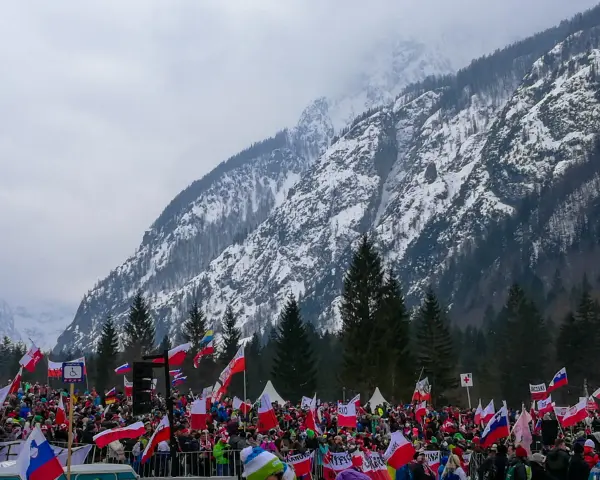 Tłum kibiców z flagami w słoweńskiej Planicy, gdzie znajduje się słynna skocznia narciarska.