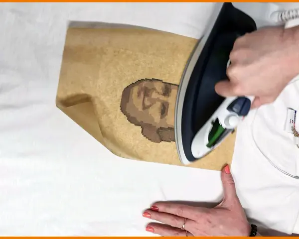 Jak zrobic naprasowanke: prasowanie papieru z pikselowym portretem na białej koszulce.