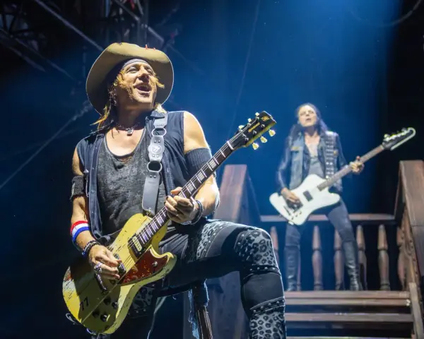 Ein Gitarrist mit Hut spielt auf der Bühne, im Hintergrund ein weiterer Musiker. Ein Konzert von Alice Cooper.