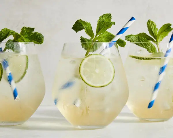 Tre svalkande Hugo Spritz med mynta och lime, perfekta för en solig dag.