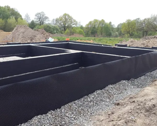 Fundament gotowy do zalania betonem. Czarna folia izolacja pozioma chroni przed wilgocią.