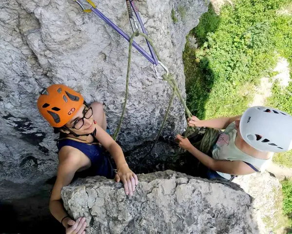 Dwie osoby w kaskach wspinają się po skale na Jurze Krakowsko-Częstochowskiej. Wspinaczka to ich pasja.