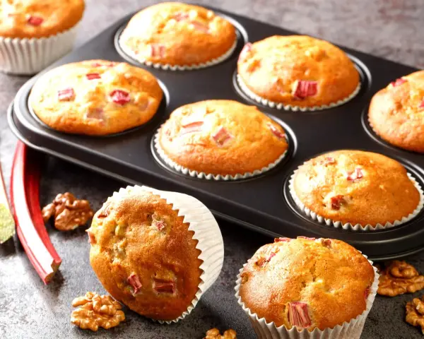 Pyszne muffinki z rabarbarem, świeżo upieczone, z kawałkami rabarbaru i orzechami włoskimi.