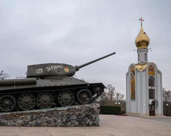 Czołg z napisem "Za Rodinu!" stoi obok cerkwi z złotą kopułą. Pomnik na nadniestrze.