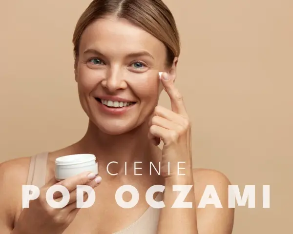 Uśmiechnięta kobieta aplikuje krem pod oczy. To rozwiązanie na cienie pod oczami, które przywróci blask Twojej skórze.