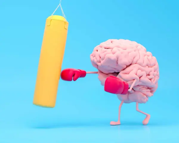 Cervello con guantoni da boxe rosa colpisce un sacco giallo, un modo per risollevare l'umore.