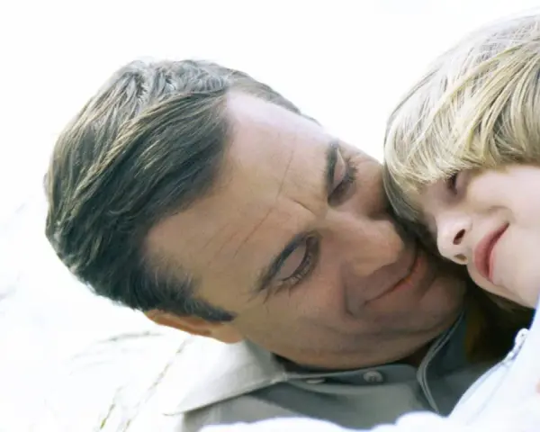 Vater und Kind kuscheln. Auch bei getrennt lebenden Eltern ist die Haftpflichtversicherung wichtig für den Nachwuchs.