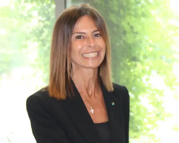 Giuseppina di Foggia, sorridente, con giacca nera e collana a croce. Forse il marito è dietro le quinte.