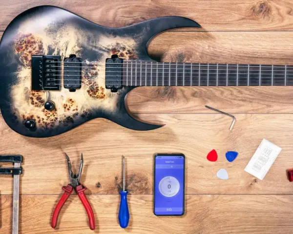 E-Gitarre aufbau: Werkzeuge, Plektren, Stimmgerät-App und ein Inbusschlüssel liegen bereit.
