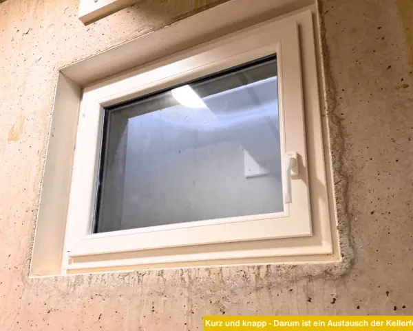 Ein neues, weißes Kellerfenster ist in eine Betonwand eingesetzt. Der Austausch des Kellerfensters verbessert die Dämmung und Sicherheit.