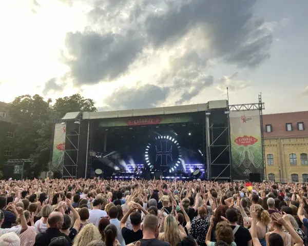 Ein riesiges Publikum feiert beim Citadel Music Festival in Berlin. Die Bühne ist beleuchtet, die Menge jubelt.