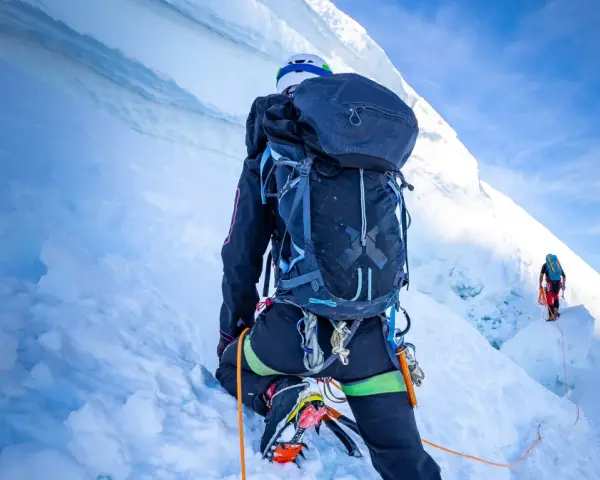 Wspinaczka na szczyt w Himalajach. Dwóch alpinistów wspinających się po lodowej ścianie, wspinaczka na szczyt w Himalajach.